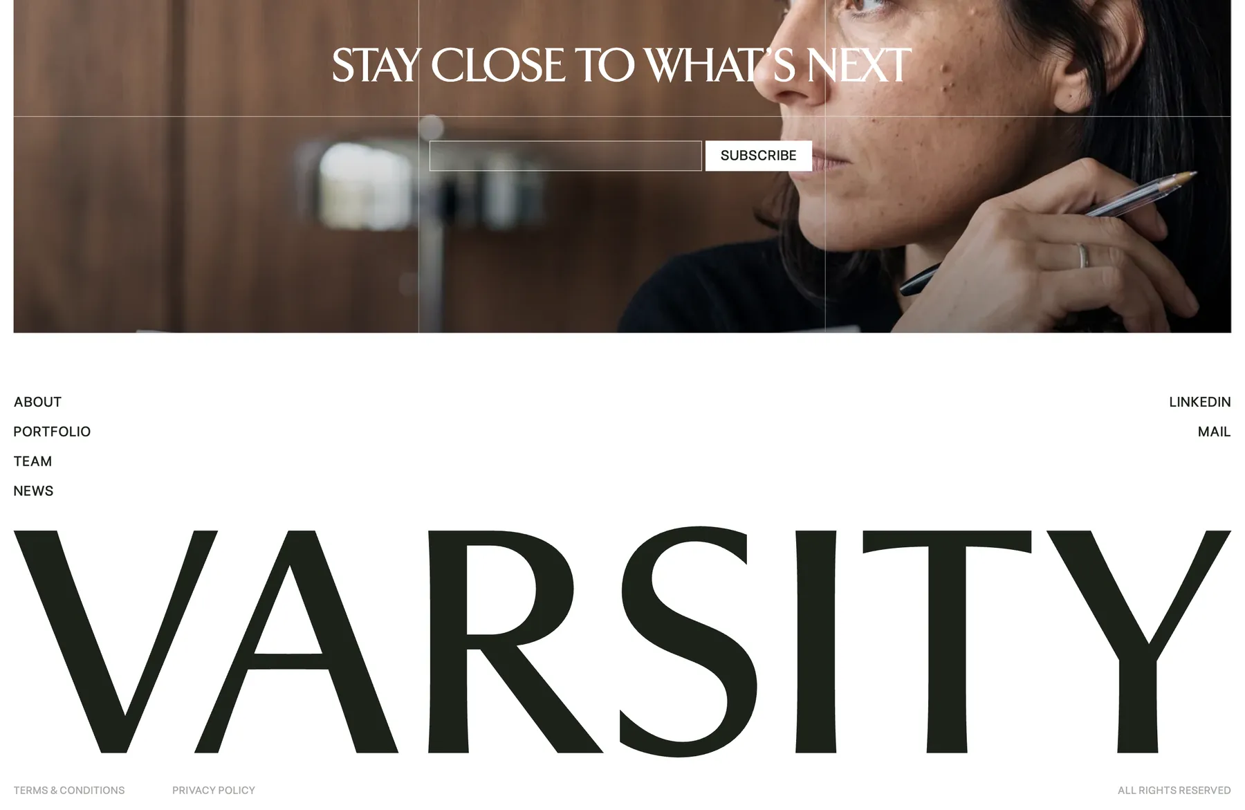 Stay close to what is next newsletter signup above the full-width Varsity wordmark in the footer